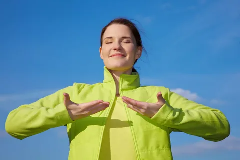Osoba sedí klidně u okna s šálkem čaje